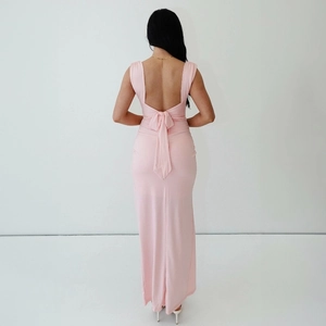 Détail du design dos nu avec un grand nœud papillon sur une robe longue rose moulante