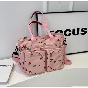 Close-up of pink cherry print tote with durable nylon multi-pocket detail and zipper pockets