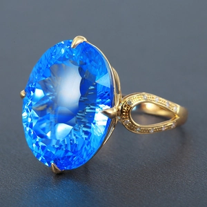 Elegant bird's nest cut blue topaz cocktail ring with gold band and pave diamond accents