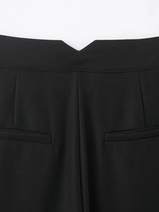 Vue détaillée du pantalon noir avec taille en V et deux poches passepoilées à l'arrière