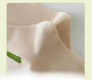 Close-up of seamless knit heel on beige cotton socks with green floral details