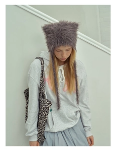 Furry cat ear hat with long tassels shown in a stylish winter streetwear fashion outfit