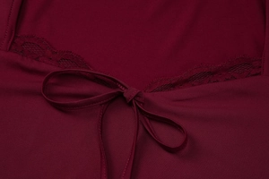 Vue détaillée du tissu en maille rouge foncé avec bordure en dentelle et nœud décoratif