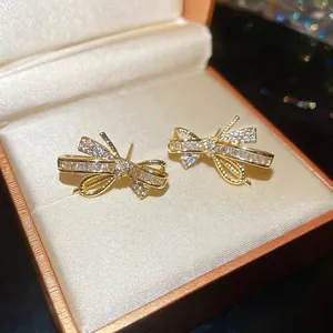 Elegant gold plated bow earrings with cubic zirconia stones in a soft jewelry box