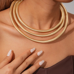 Detail view of triple-layered golden snake chain necklace with spiral metallic texture