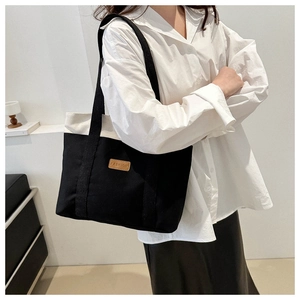 Fashionable black and white canvas tote bag shown as a stylish large capacity shoulder bag