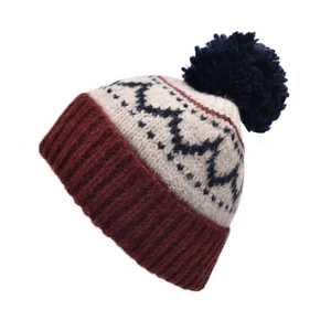 Détail d'un bonnet en tricot jacquard vintage avec un pompon moelleux pour l'hiver