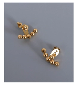 Close-up of golden titanium steel earrings with a curved five-bead gradient design
