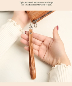 Close-up of brown leather wallet featuring premium metal zipper and detachable wrist strap