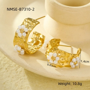 Detail view of 18K gold plated C-shaped earrings with pearls and lava texture design