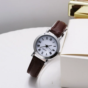 Macro detail of the vintage quartz watch with Roman numerals and dark brown leather strap