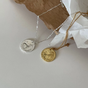 Detailed relief of a brave lion on vintage gold and silver coin necklaces in a 45-degree view