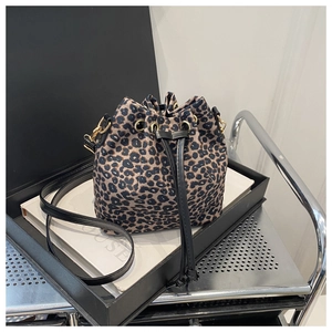 Détail du sac seau à imprimé léopard avec cordon noir et accessoires dorés élégants