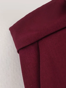 Close-up detail of dark red twill fabric on the lapel collar of this vintage jacket