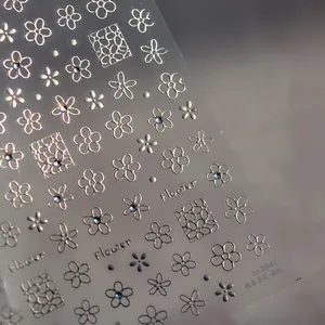 Macro détail de stickers à ongles fleurs argentées avec strass en cristal et lignes