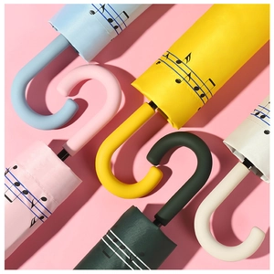 Detail of J-shaped frosted umbrella handles in five pastel colors with music note patterns