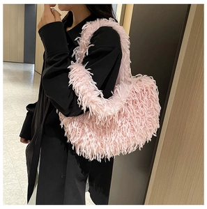 Sac à épaule en plumes d'autruche rose porté avec une robe noire pour l'automne