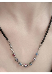 Close-up of rainbow gemstone extension chain necklace on model with vintage dice pendant