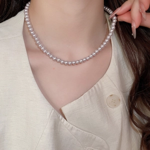 Close-up of pink pearl necklace on neck showing smooth texture and soft luster