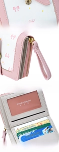 Detailed view of pink and white bow wallet showing zippers and internal compartments