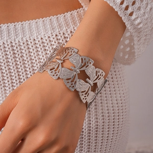 Close-up of silver hollow butterfly cuff bracelet with intricate metallic texture details