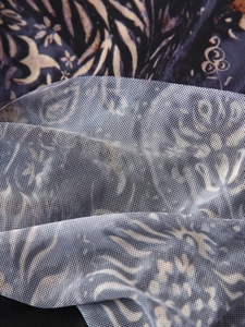 Détail macro du tissu en maille transparente avec des motifs abstraits violets