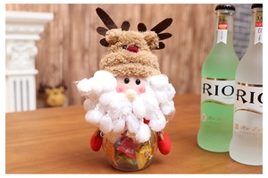 Close-up of a Santa reindeer plush candy jar filled with colorful sweets on a wooden table