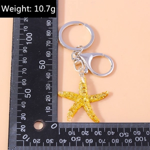 Detail view of golden starfish keychain with ruler measurement and 10.7g weight info