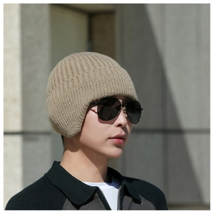 Close-up of khaki winter knit hat featuring ear protection and thick wool texture