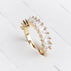 Detailed close-up of golden ring with rectangle zircons and elegant claw setting