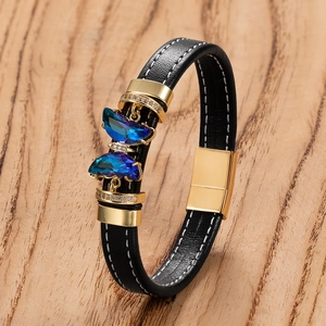 Vue détaillée du bracelet en cuir noir avec gemmes papillon bleues sur bois