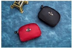 Detail of mini leather coin purses with bee hardware in red and black colors