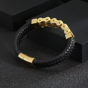 Detail of black braided leather bracelet with gold stainless steel bicycle chain links