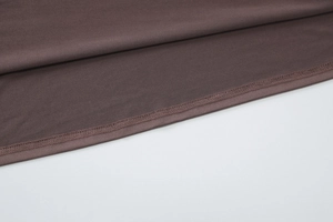 Gros plan du tissu marron café montrant la texture douce et les coutures de qualité