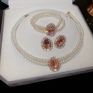 Detail of luxury pearl jewelry set with oval pink gemstones and crystal pavé details