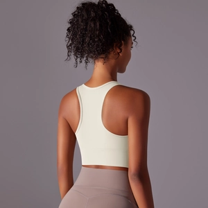Detail of cream racerback sports bra showing high-elasticity fabric and back cut-out
