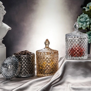 Three elegant glass storage jars with diamond patterns on silk fabric with floral background