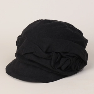 Detail of breathable pleated black linen fabric texture on a vintage newsboy cap