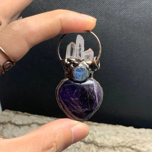 Detailed macro view of heart amethyst pendant with crystal clusters and copper plating
