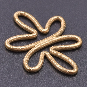 Macro shot of gold-plated stainless steel flower charm with textured hammer finish
