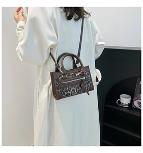 Detalle del bolso con estampado de leopardo, bolsillo con cremallera y ribete marrón