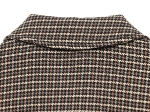 Close-up of the lapel collar showing the houndstooth pattern and thick tweed fabric texture