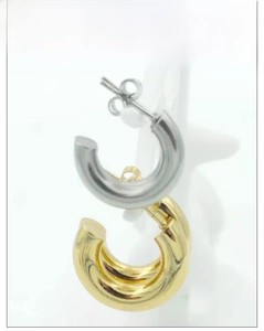 Detailed view of chunky C-shape hoop earrings in polished gold and silver finishes