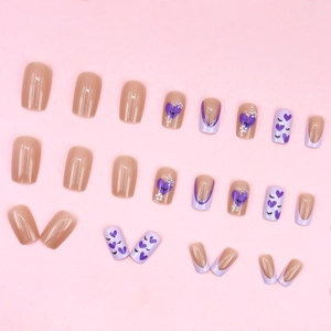 Pastel purple and nude press-on nails with heart patterns and French tips design