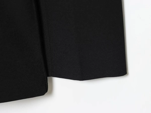 Vue macro détaillée de la texture du tissu noir et des coutures du blazer de costume