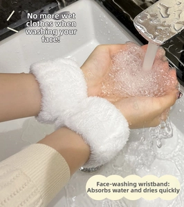 Close-up of white plush spa wristbands absorbing water to prevent wet sleeves during face wash