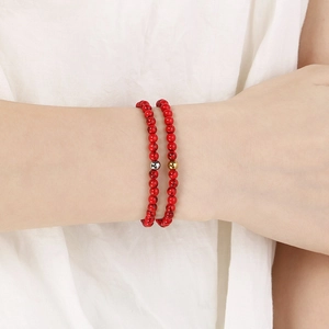Détail macro de bracelets en perles de pierre rouge avec motifs marbrés et perles en métal