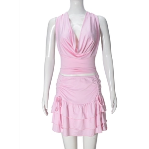 Detail of pink two-piece set featuring halter neck top and tiered drawstring mini skirt