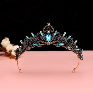Detailed view of baroque vintage bronze crown with blue gems and black rhinestones