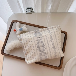 Detail of cotton makeup bag with vintage floral pattern and 'simple wish' label